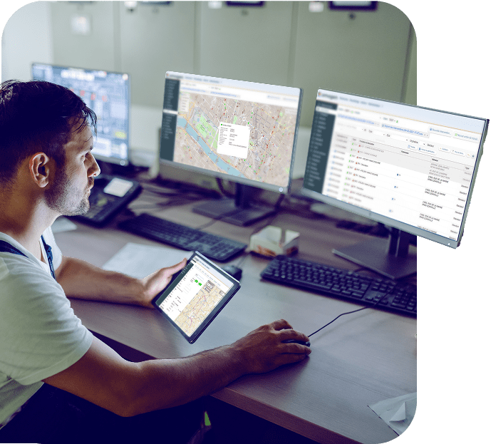 Un opérateur en salle de contrôle utilise la GMAO Omogen affichée sur plusieurs écrans et une tablette, avec une carte interactive et une liste d’interventions.