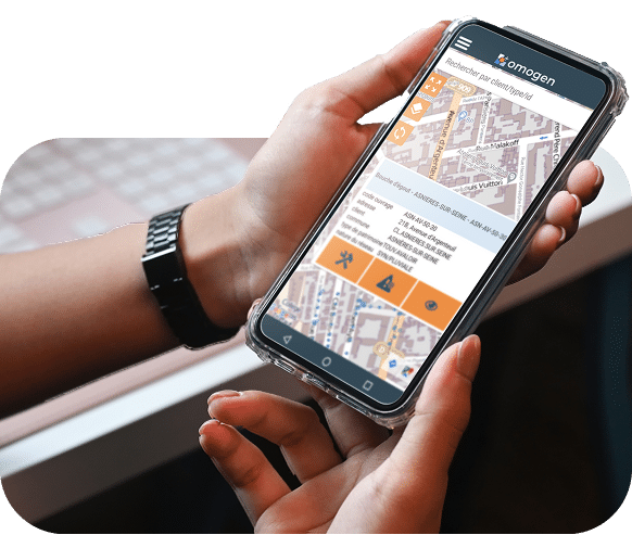 Une personne tient un smartphone affichant l’application omogen avec une carte interactive