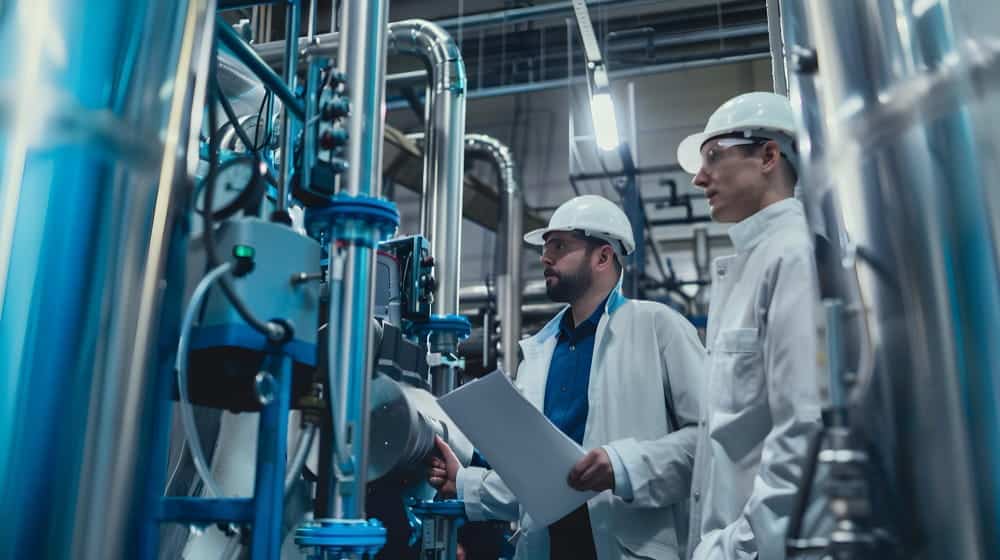 Ingénieurs calibrant des capteurs dans une installation de traitement des eaux usées ; ils ajustent des équipements dans une salle de contrôle pour assurer la précision des mesures.