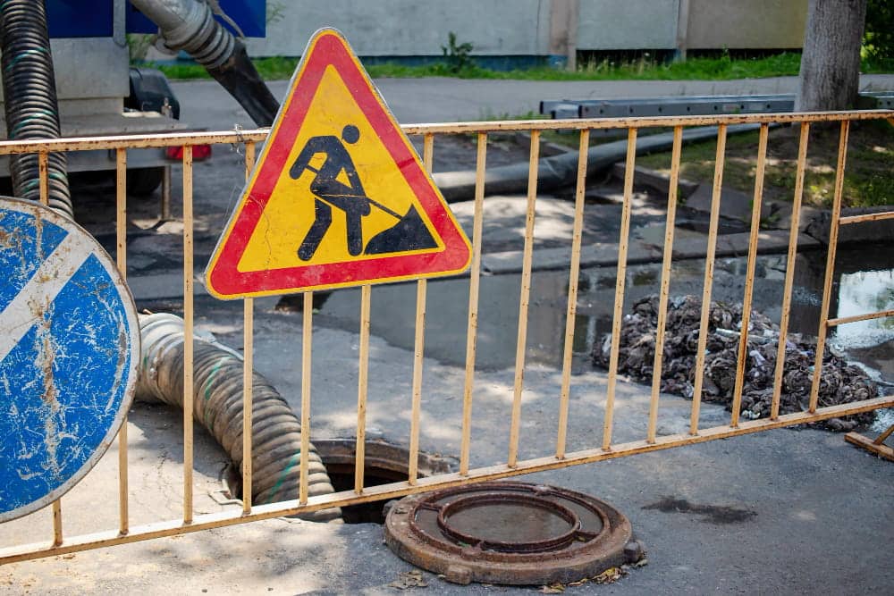 Travaux sur un regard d’assainissement ouvert dans une rue de collectivité
