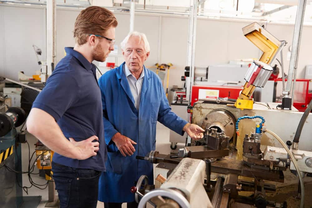 Ingénieur senior transmettant son expérience à un apprenti en atelier